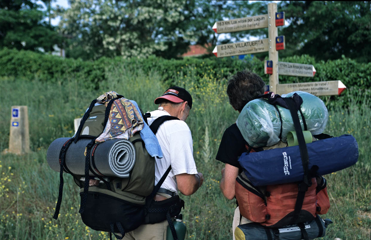 Buen Camino By Checco Zalone: The Real Camino De Santiago, And How To Do It By Bike 2 Pilgrims With Backpacks In Front Of A Camino Signpost In Navarre